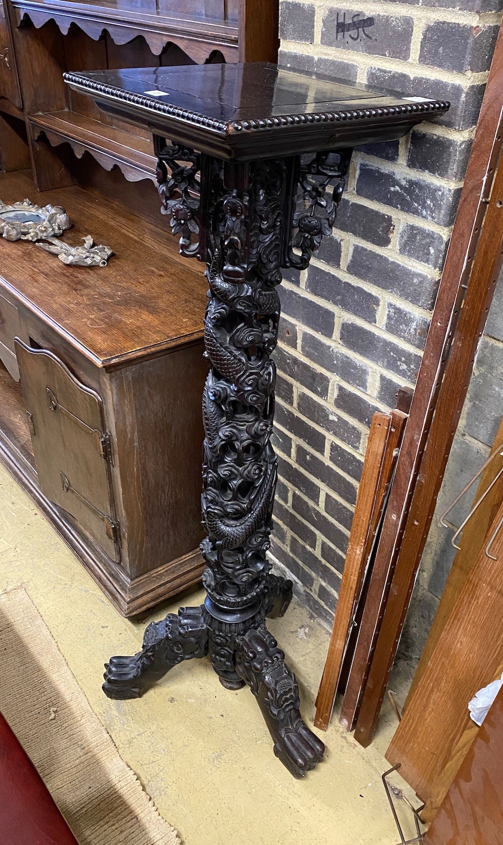 A Chinese ebonised hardwood pedestal stand, width 42cm, height 136cm